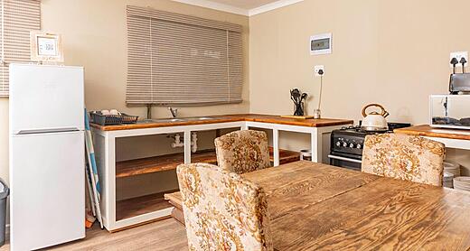 Shared kitchen for the twin rooms, with a stove, fridge and dining table