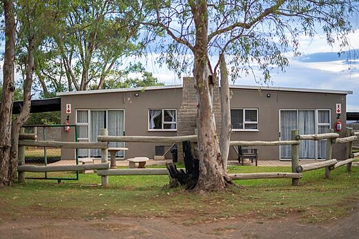 Single-storey guest units behind a timber fence at Amberdale Estate